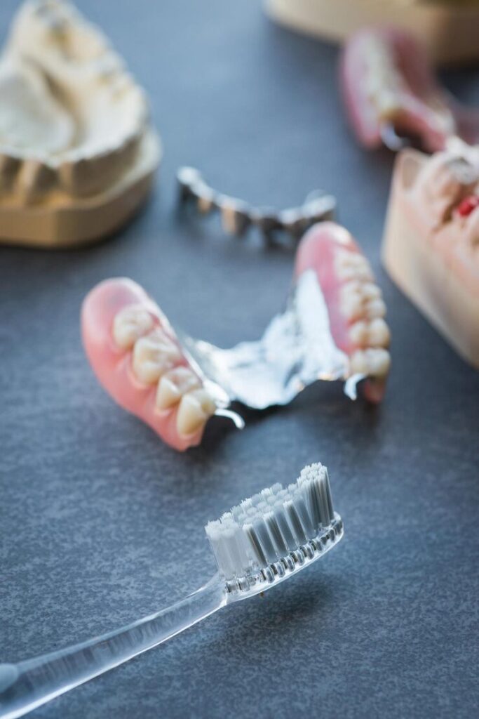 artificial-replacement-teeth-with-tooth-brush-dark-table_689970-1692